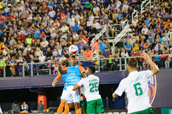 A Miami FC player heads the ball