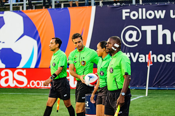The referee picks up the ball