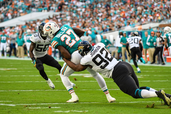 Jacksonville Jaguars defensive end Lyndon Johnson (92) tackles Miami Dolphins running back Kalen Ballage (27) for a loss